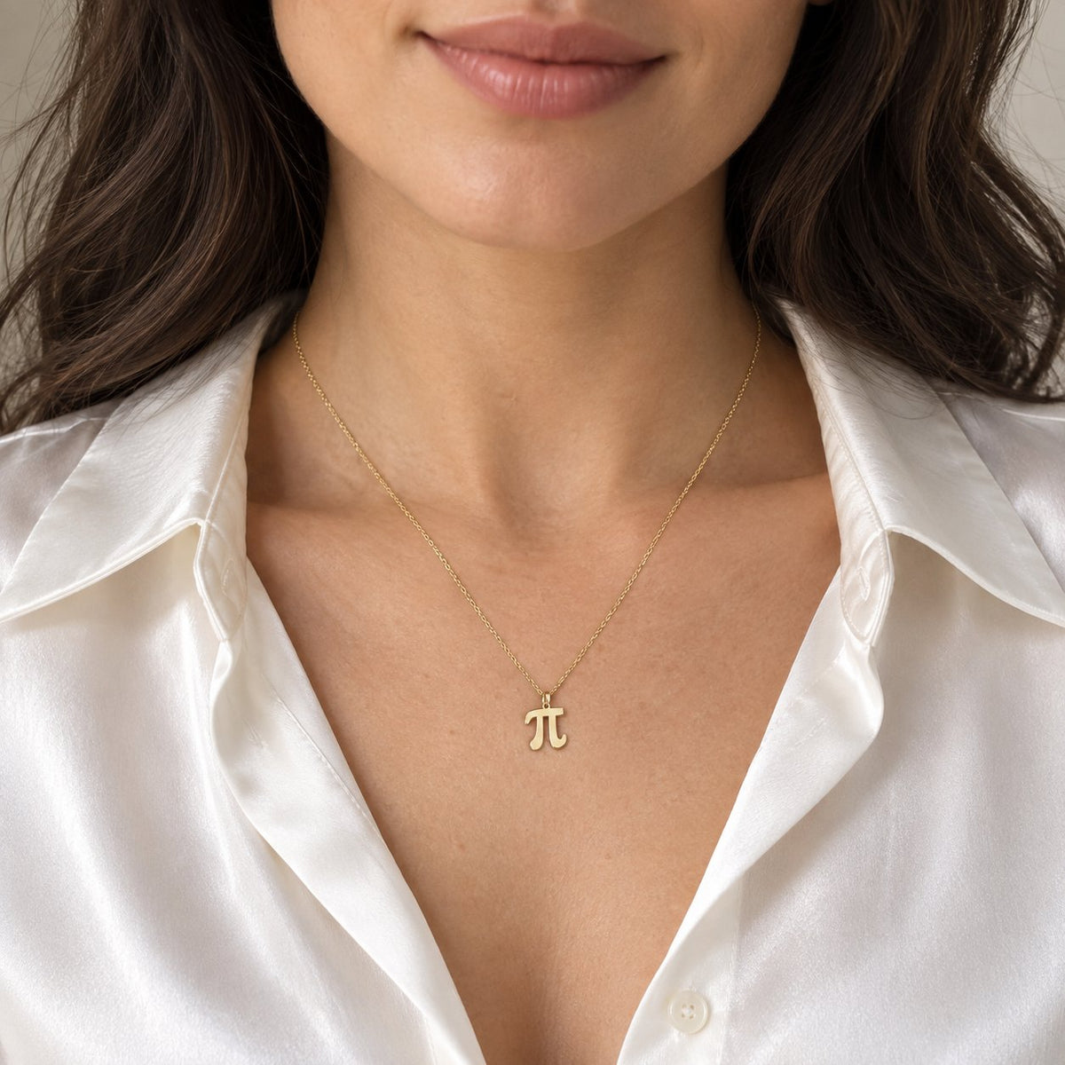 14K solid gold Pi Math necklace on woman wearing white satin shirt